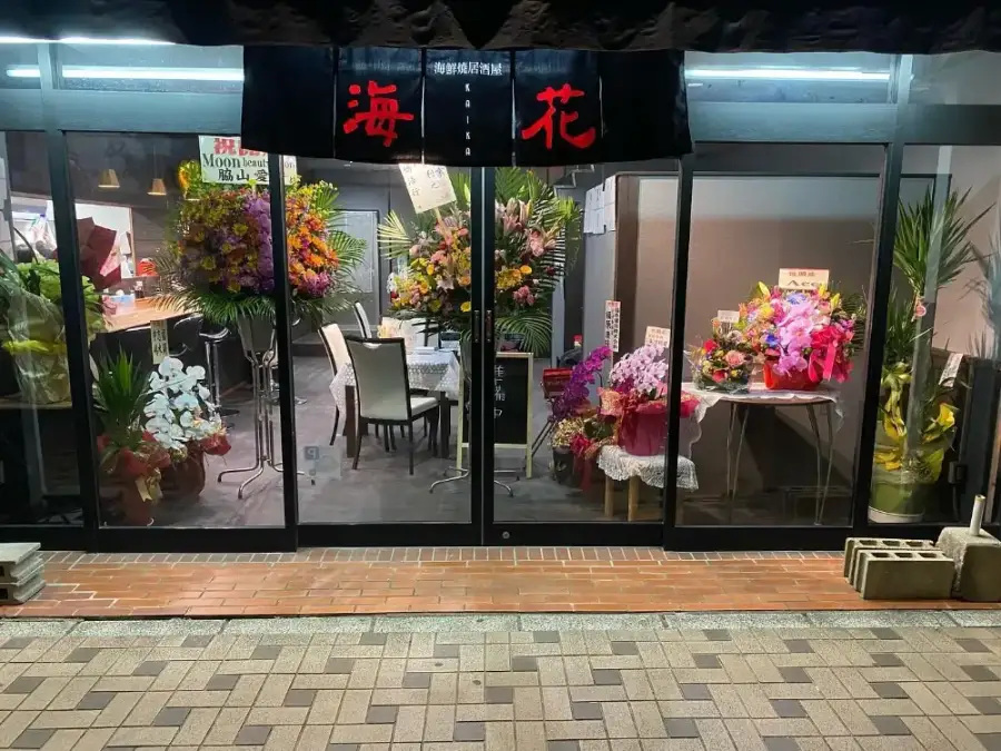 開店祝いの花が並ぶ海鮮焼き居酒屋 海花の外観