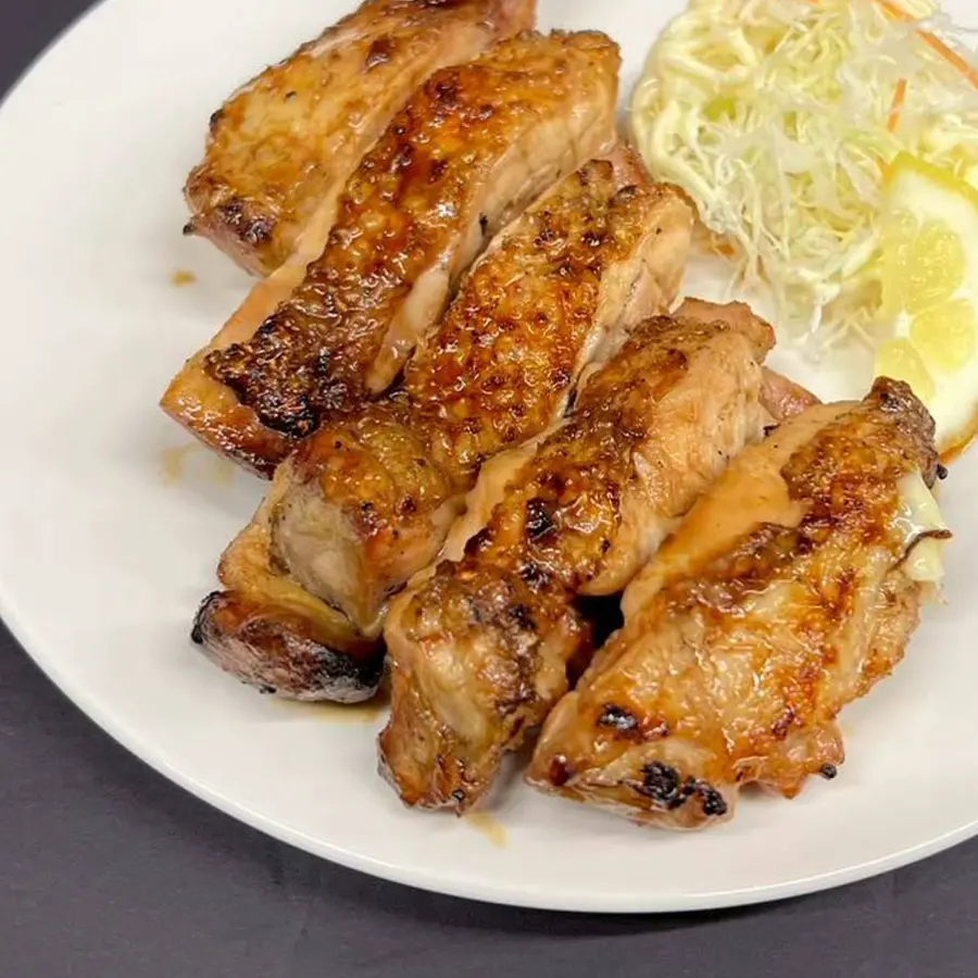 千切りキャベツとレモンを添えた鶏モモ焼き